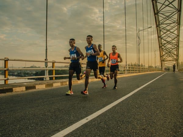 four men running on asphalt floor