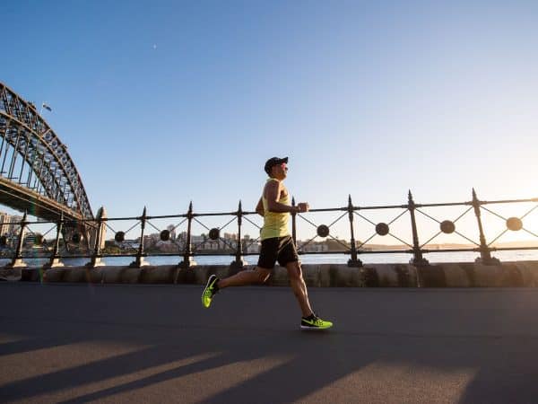 man in yellow tank top running near shore